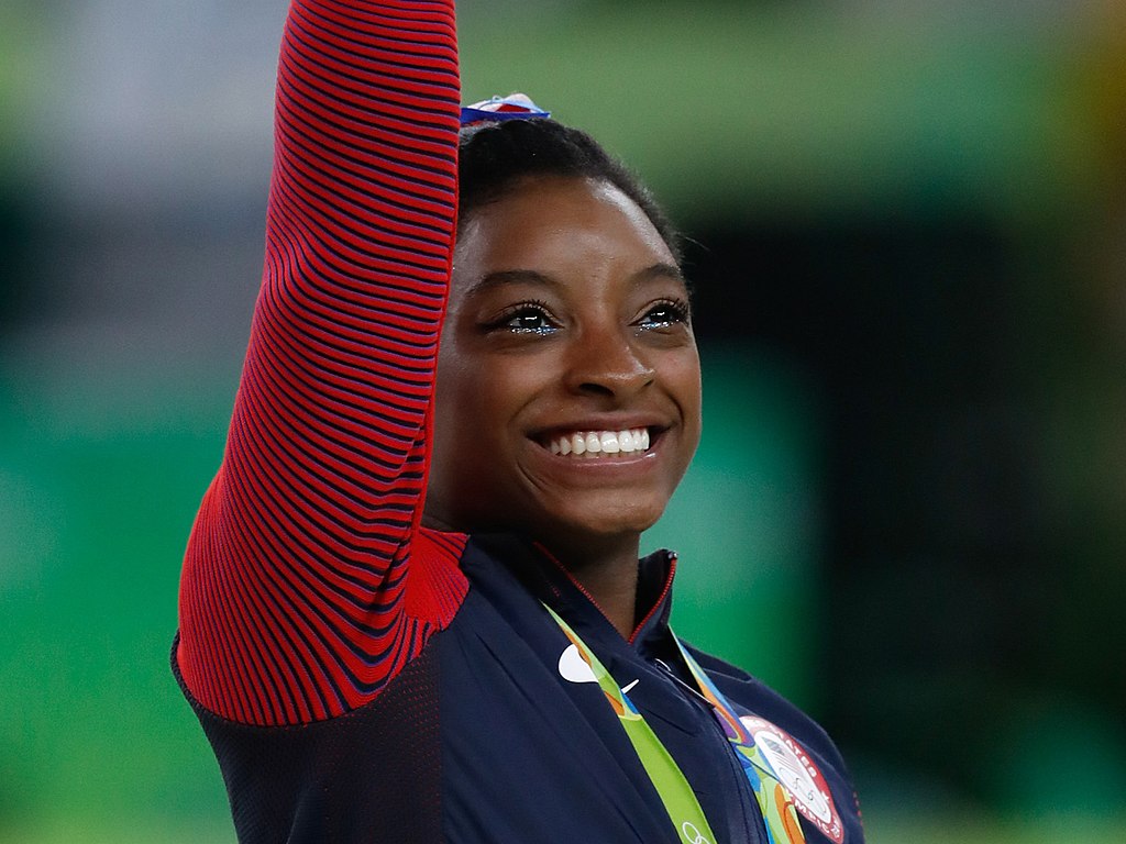 1024px Simone Biles at the 2016 Olympics all around gold medal podium 28262782114 cropped